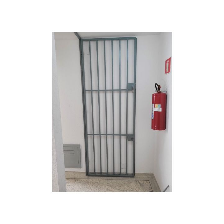 Porta grade de ferro instalada em corredor de prédio – Serralheria Carvalho